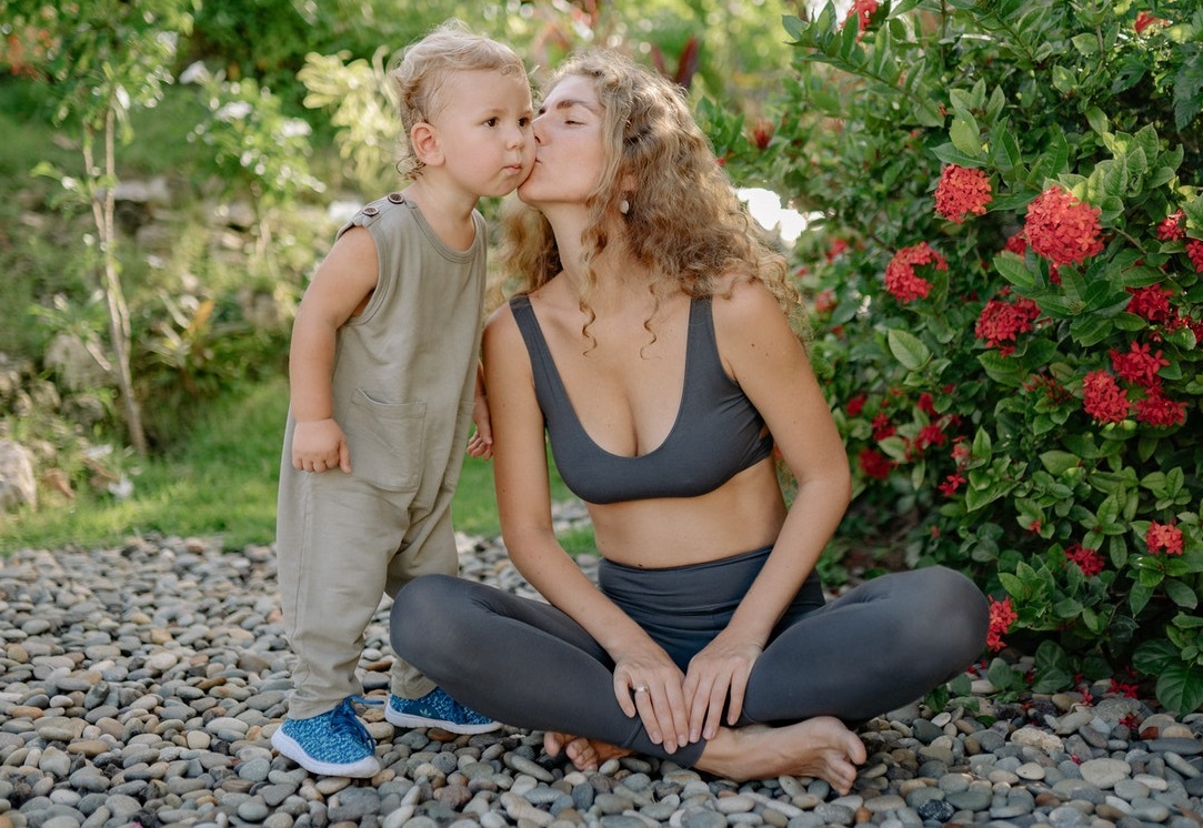 mother-kissing-little-sons-cheek-in-park