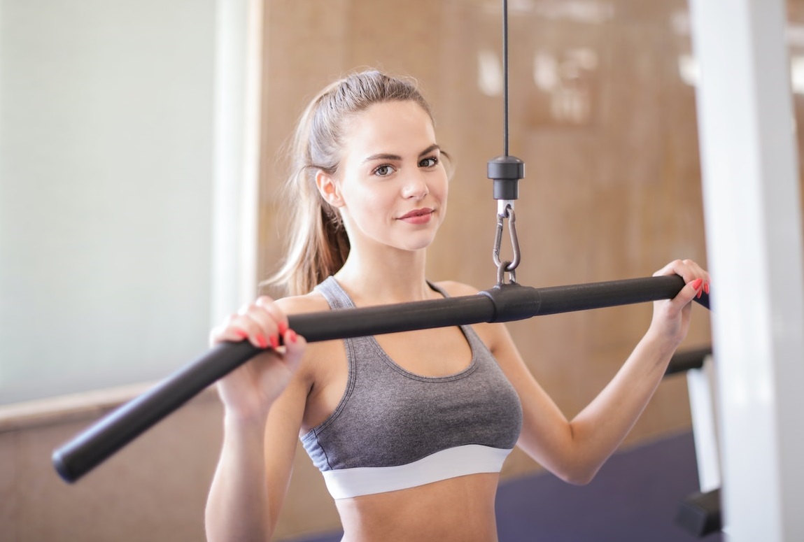 woman lifting weights wearing grey sports bra
