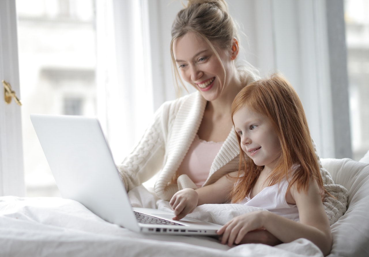 Woman teaching kid on laptop