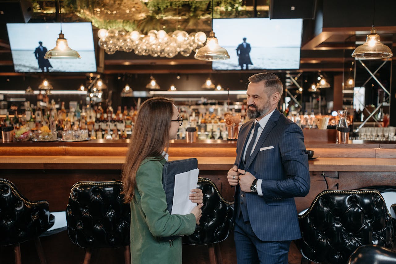 man and a woman talking near bar counter