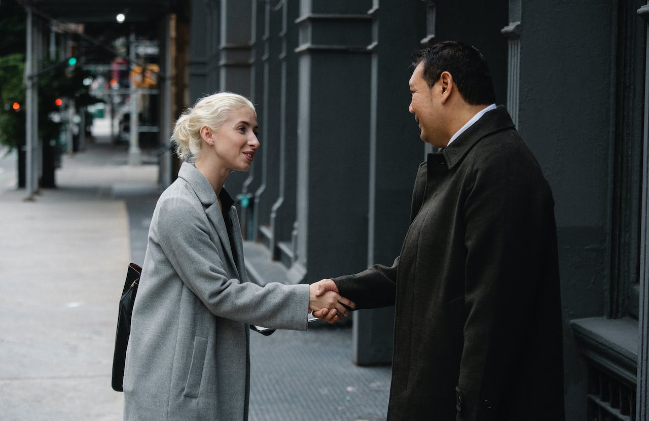 young woman shaking hands with a man