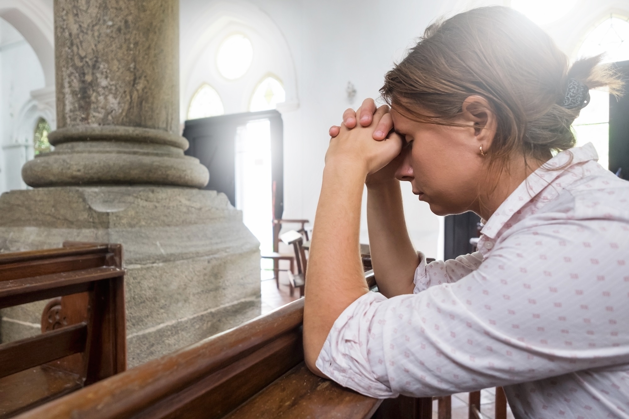 sad woman praying in church