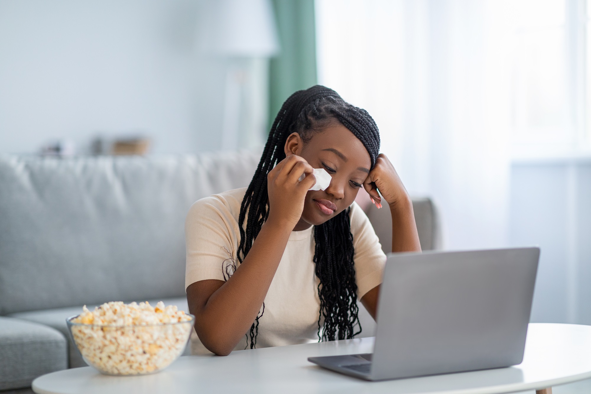 Upset black lady watching melodrama and crying