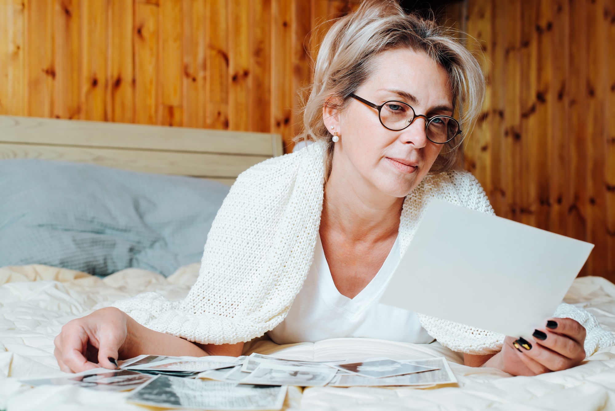 woman nostalgia holding old photos from family album