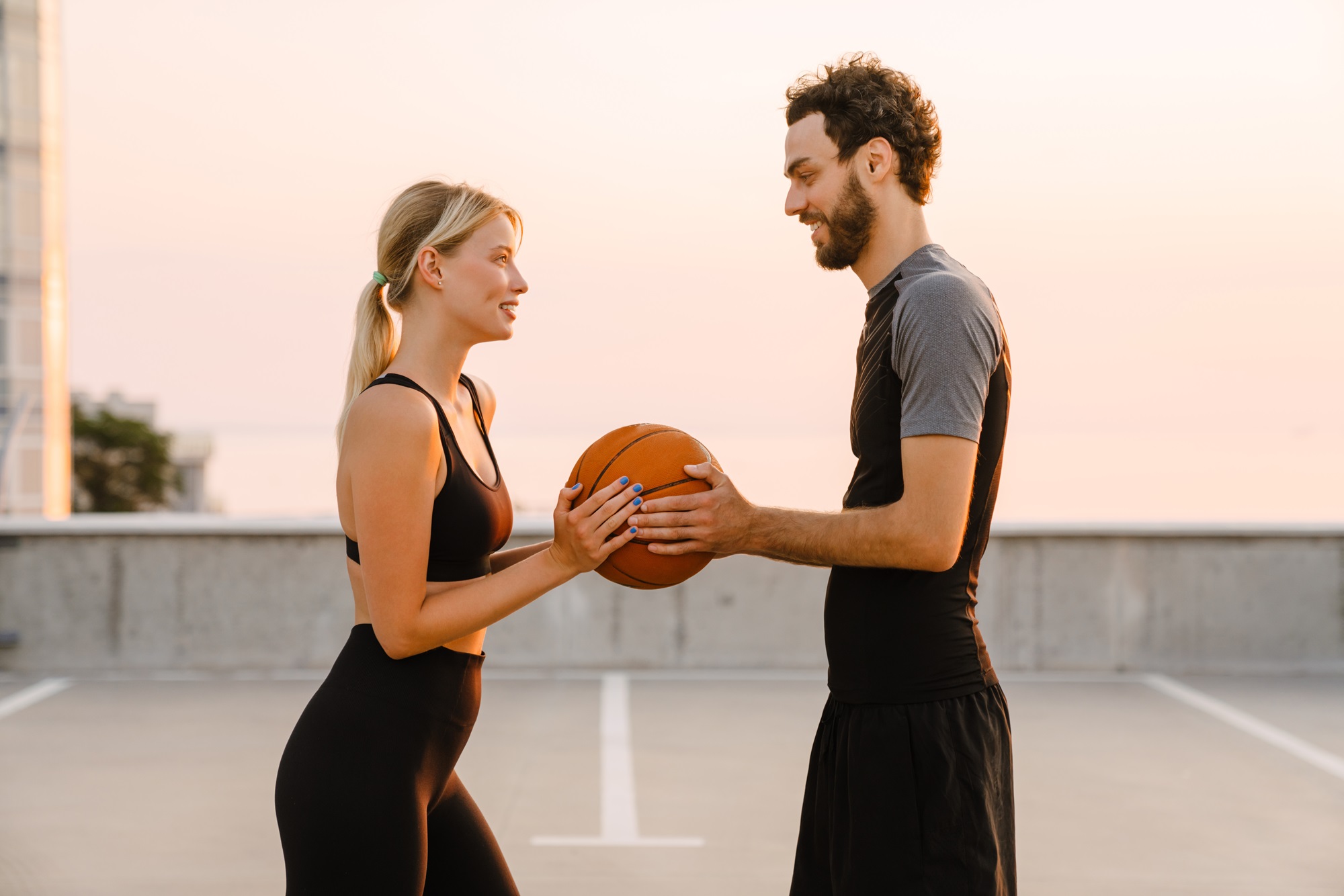 Young man and woman playing with ball together