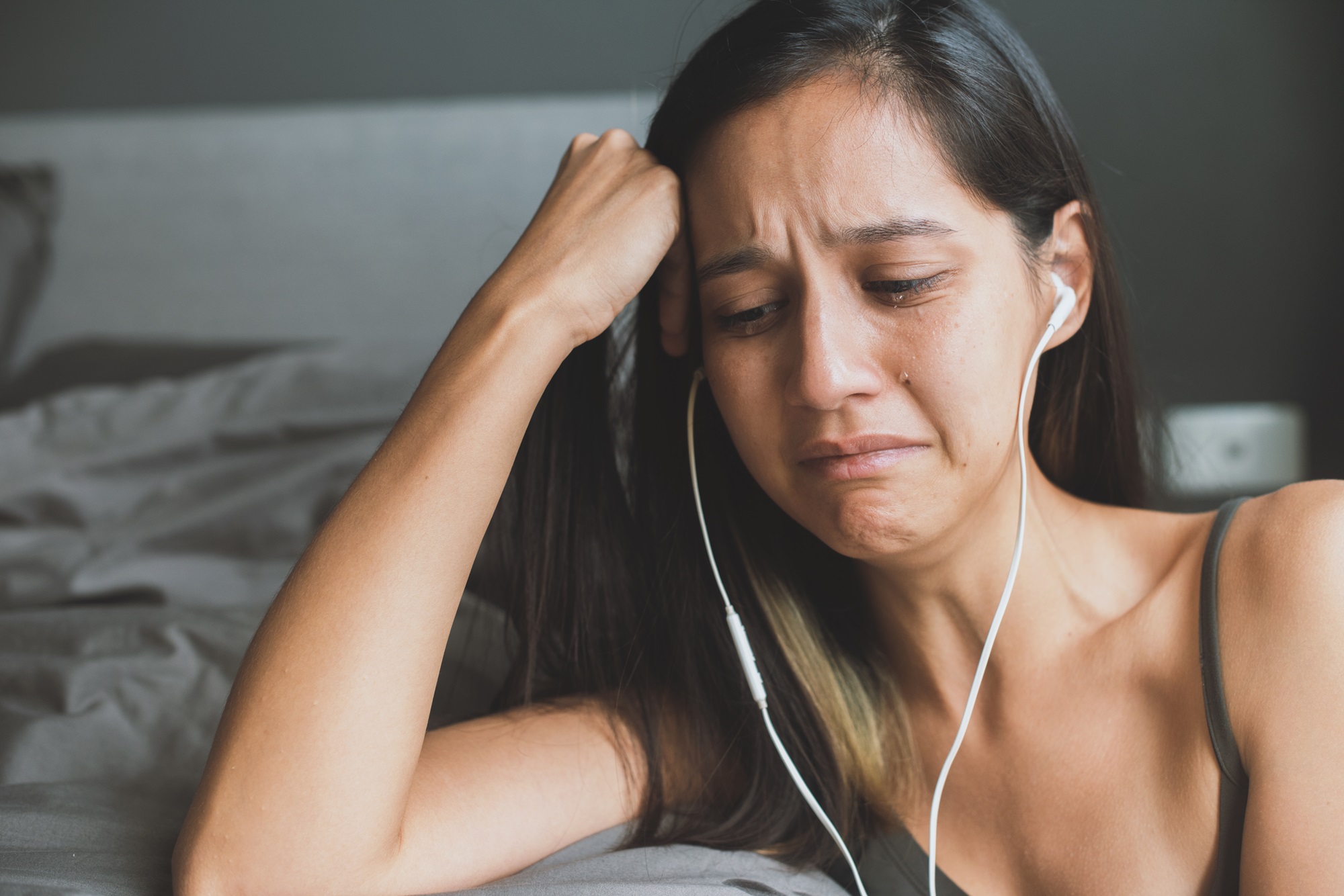 young woman crying while listining emotional songs